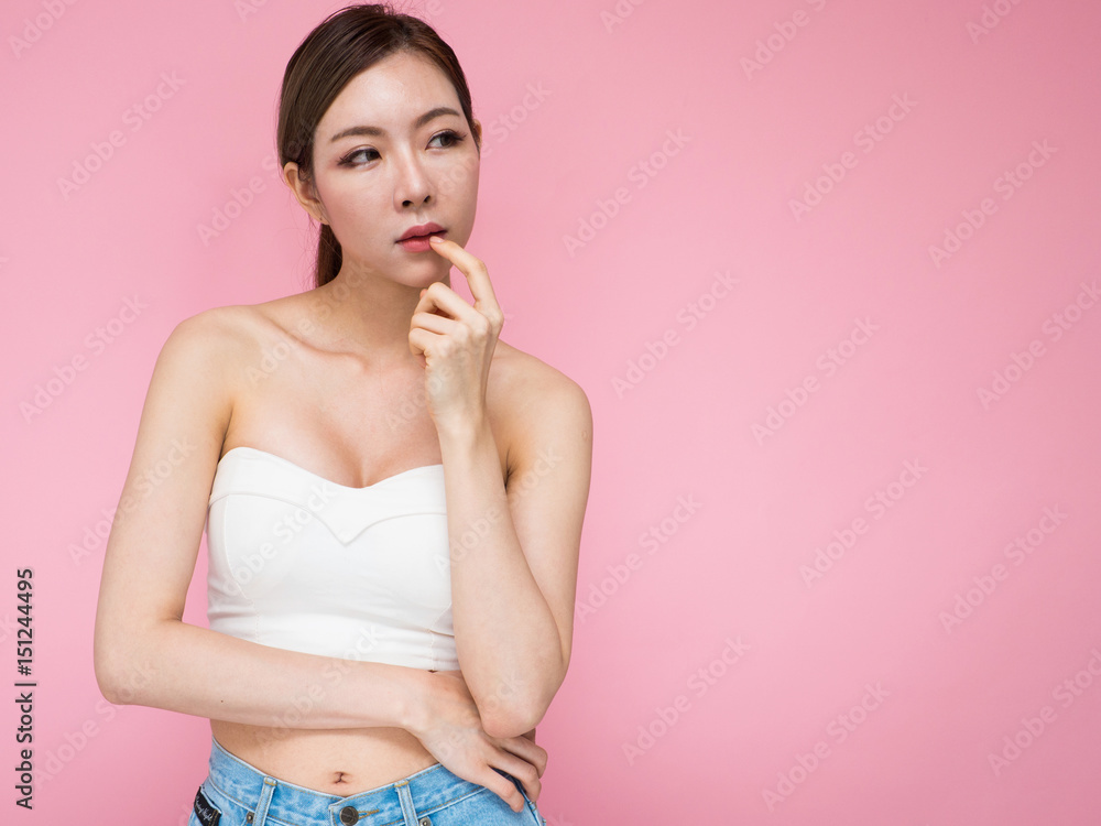 Spa Woman Portrait. Beautiful Asian Girl Touching her Face. Perfect Fresh Skin. Pure Beauty Model Female looking at camera. Youth and Skin Care Concept.on pink background with copy space Spa Woman Portrait. Beautiful Asian Girl Touching her Face. Perfect Fresh Skin. Pure Beauty Model Female looking at camera. Youth and Skin Care Concept.on pink background with copy space