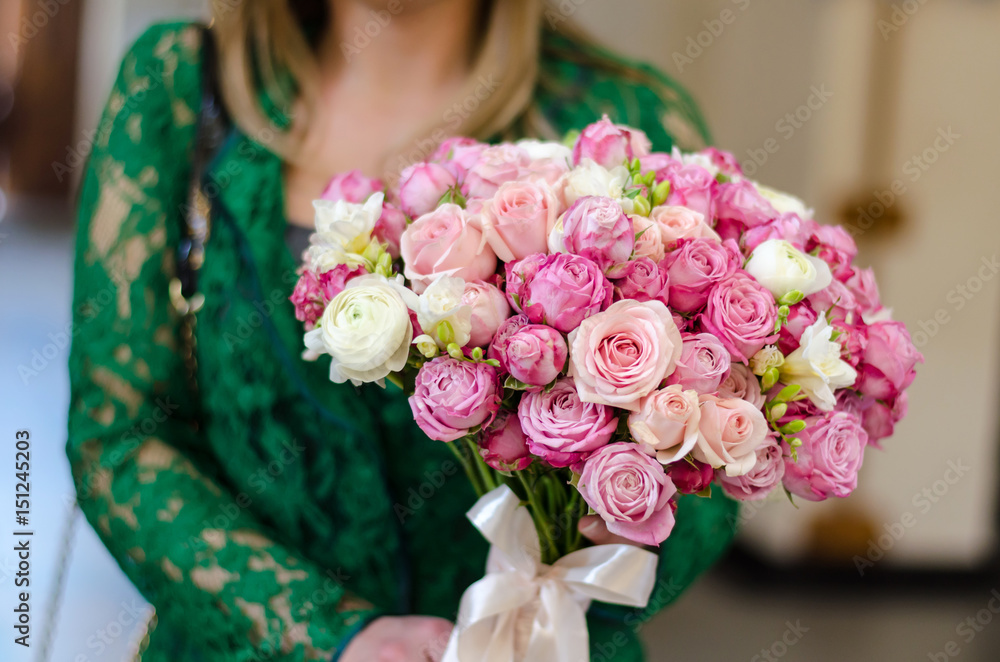 Naklejka premium A woman is holding flowers in her hands