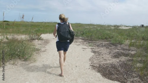 Woman with backpack walking on sand path Masonboro Island photo