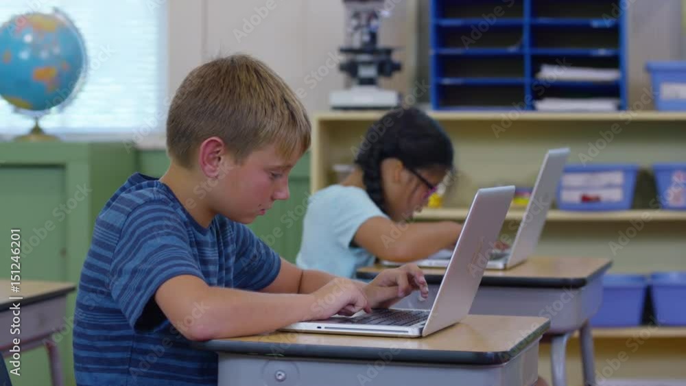 Students in school classroom working on laptop computers Students in school classroom working on laptop computers