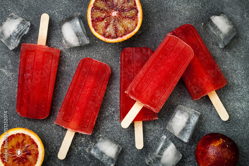 Homemade frozen blood orange natural juice alcoholic popsicles - paletas - ice pops. Overhead, flat lay, top view