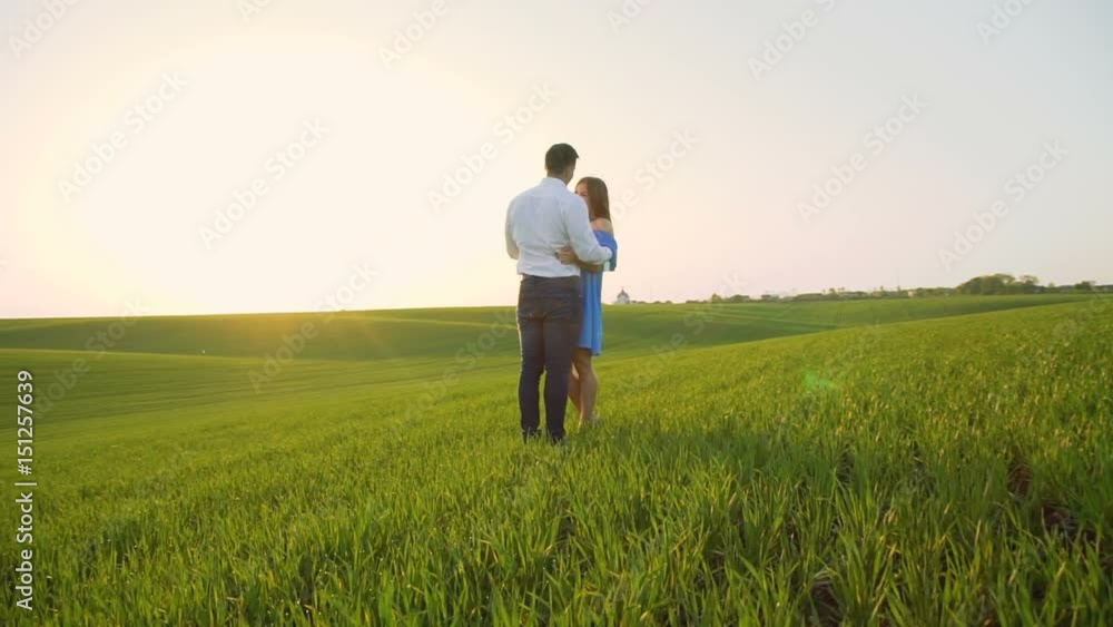 Couple in love stands in embraces, looking and kissing each other on the horizon Couple in love stands in embraces, looking and kissing each other on the horizon