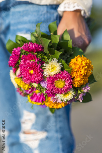 Young woman holding a bouquet of flowers in his hand outside