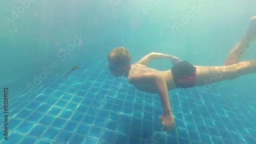 happy child swims with enjoyment under the water in the pool