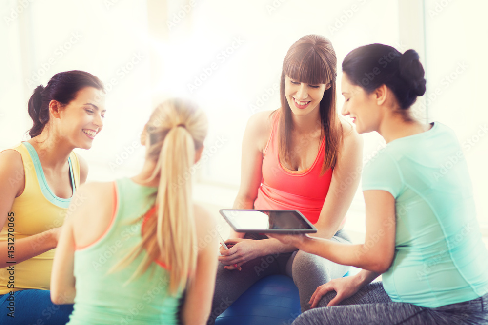 happy pregnant women with gadgets in gym happy pregnant women with gadgets in gym