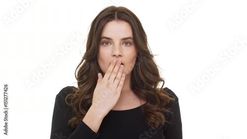 Surprised Caucasian female with burnette long hair covering mouth with hand standing on white background photo