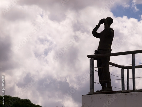 Silhouette of man looking through binoculars