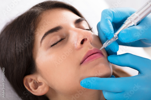 Cosmetologist Applying Permanent Make Up On Lips