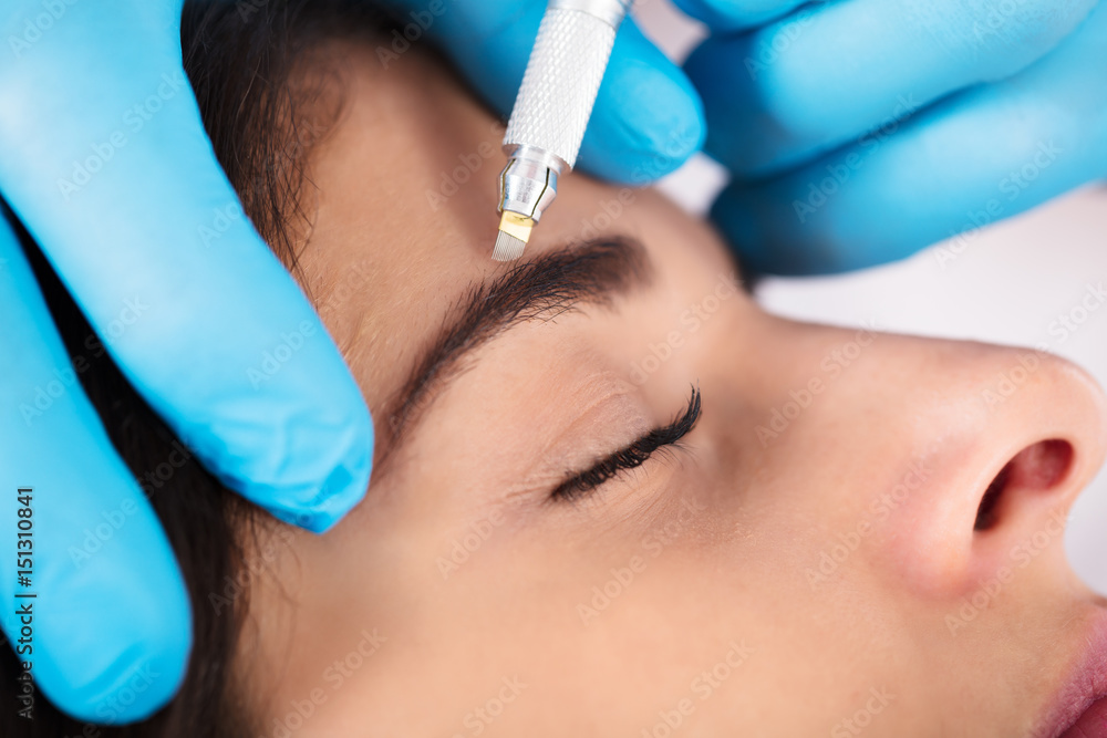 Cosmetologist Applying Permanent Make Up On Eyebrows Cosmetologist Applying Permanent Make Up On Eyebrows