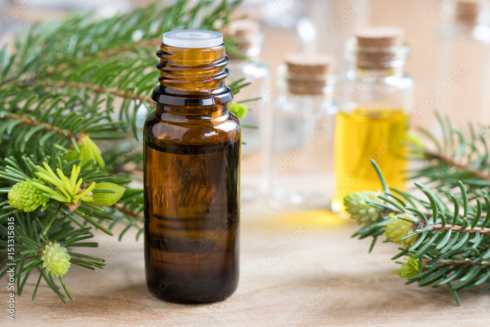 A bottle of fir essential oil with fir branches A bottle of fir essential oil with fir branches