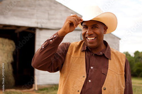 African American cowboy smiling and tipping his hat