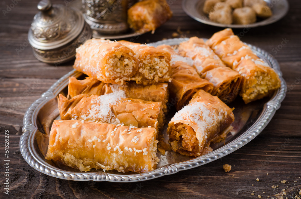 Homemade baklava rolls in iron try on wooden background. Ramadan food. Selective focus Homemade baklava rolls in iron try on wooden background. Ramadan food. Selective focus