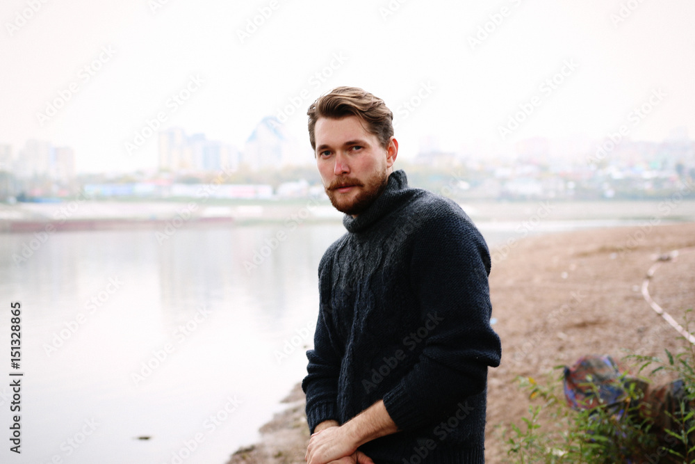 Handsome bearded man on the background of the river