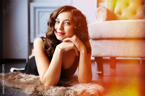 Young beautiful woman lying on polished floor in studio