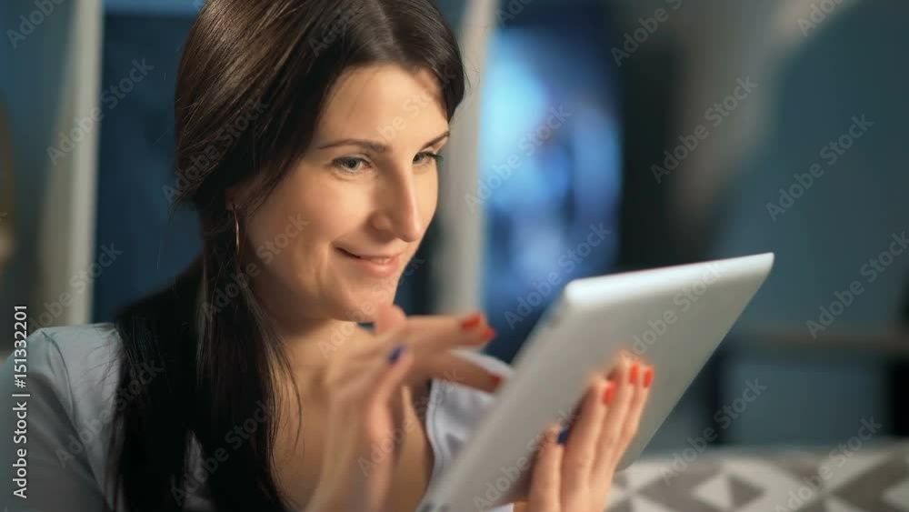 Woman using digital tablet at home sitting on sofa Woman using digital tablet at home sitting on sofa