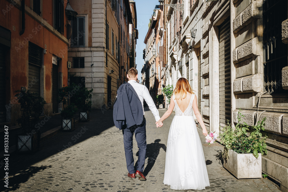 Bride and groom posing on the old streets of Rome, Italy