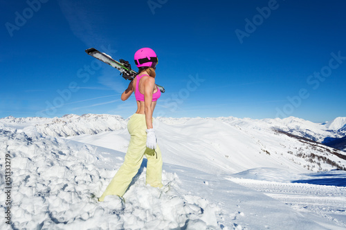 Cool female skier looking at snowy peaks