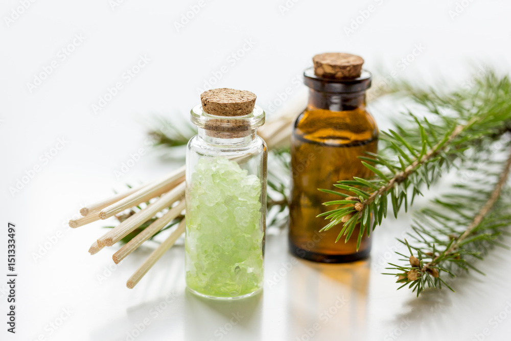 Spruce needle aromatherapy essential oils and salt in bottles on white table background