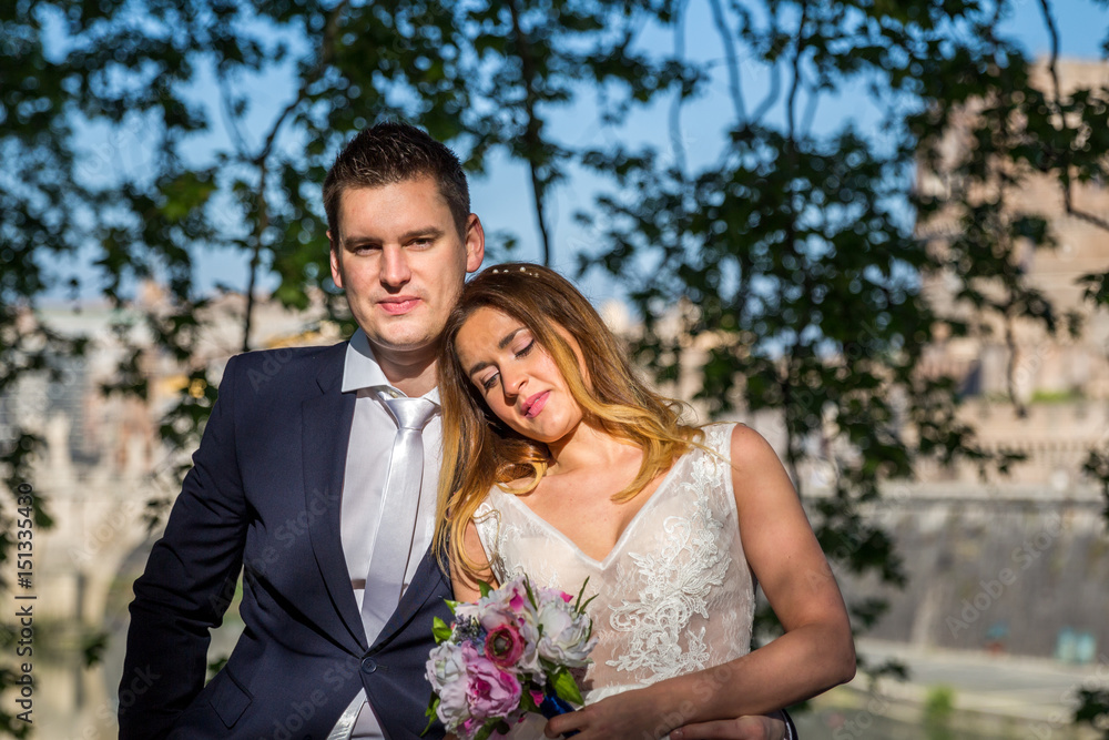 Bride and groom wedding poses under trees on the bank of the river Tiber, Rome, Italy Bride and groom wedding poses under trees on the bank of the river Tiber, Rome, Italy