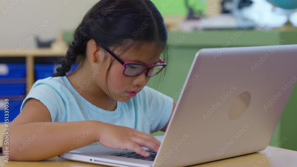 Girl in school classroom working on laptop computer Girl in school classroom working on laptop computer