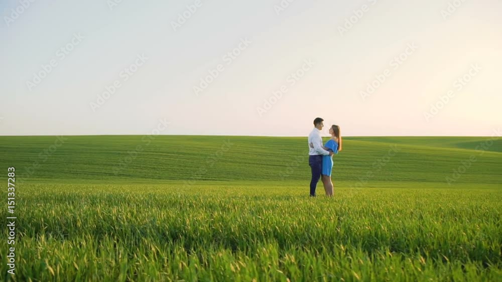 Couple in love stands in embraces, looking and kissing each other on the horizon Couple in love stands in embraces, looking and kissing each other on the horizon