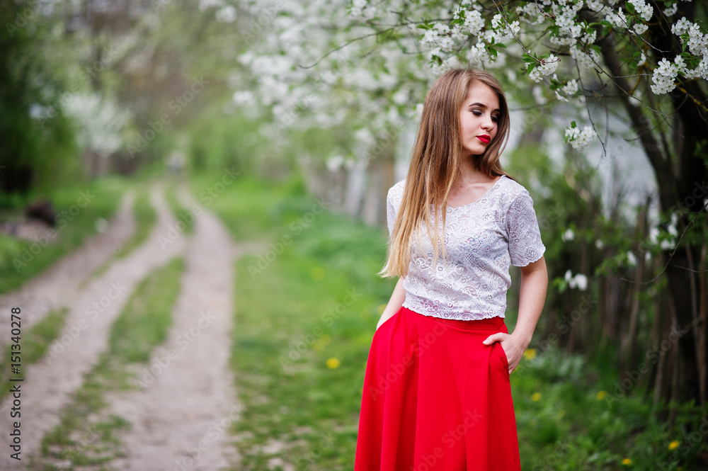 Portrait of beautiful girl with red lips at spring blossom garden, wear on red dress and white blouse. Portrait of beautiful girl with red lips at spring blossom garden, wear on red dress and white blouse.