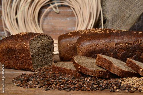 Fresh sliced bread with seeds on wooden and textile background