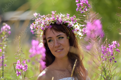 Brunette in white in summer tea willow field with wreath on head photo