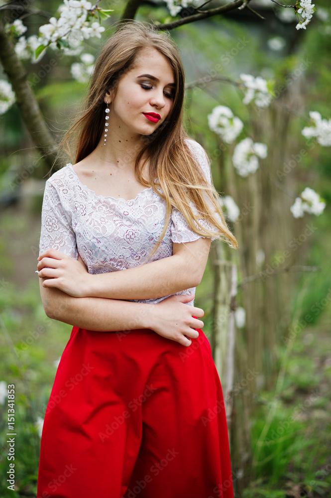 Portrait of beautiful girl with red lips at spring blossom garden, wear on red dress and white blouse. Portrait of beautiful girl with red lips at spring blossom garden, wear on red dress and white blouse.