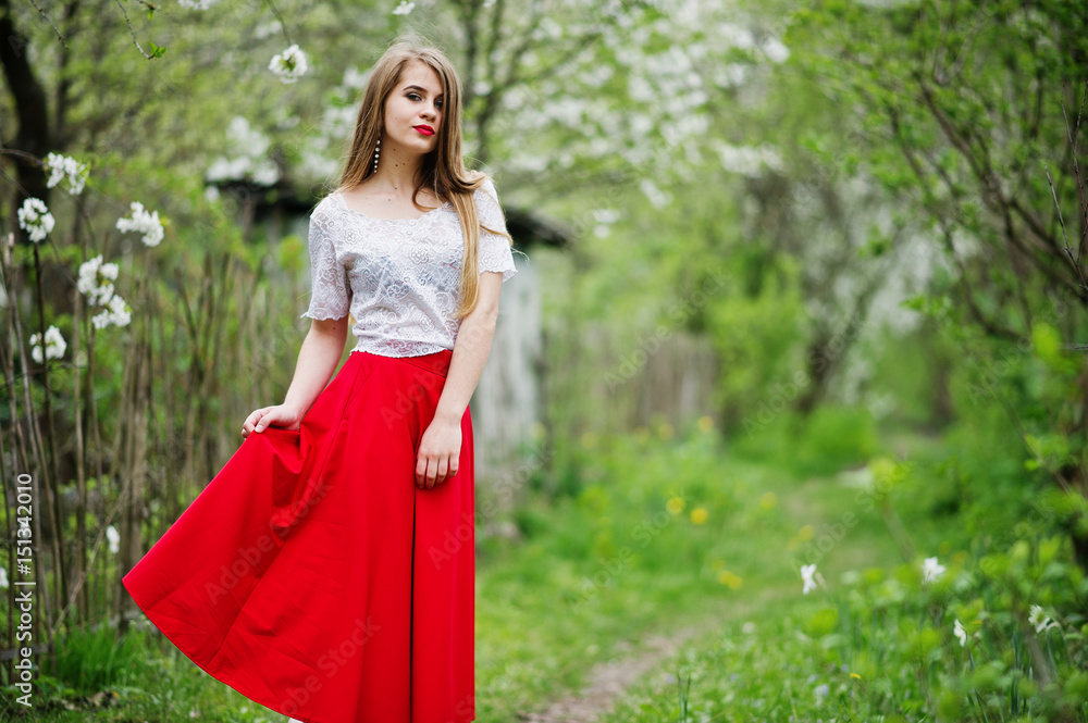 Portrait of beautiful girl with red lips at spring blossom garden, wear on red dress and white blouse. Portrait of beautiful girl with red lips at spring blossom garden, wear on red dress and white blouse.