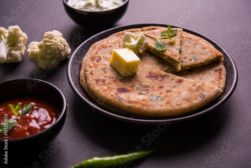 Stuffed Gobi Paratha or cauliflower paratha is a Indian flatbread. favourite breakfast or lunch menu in north India, served with curd and tomato ketchup photo