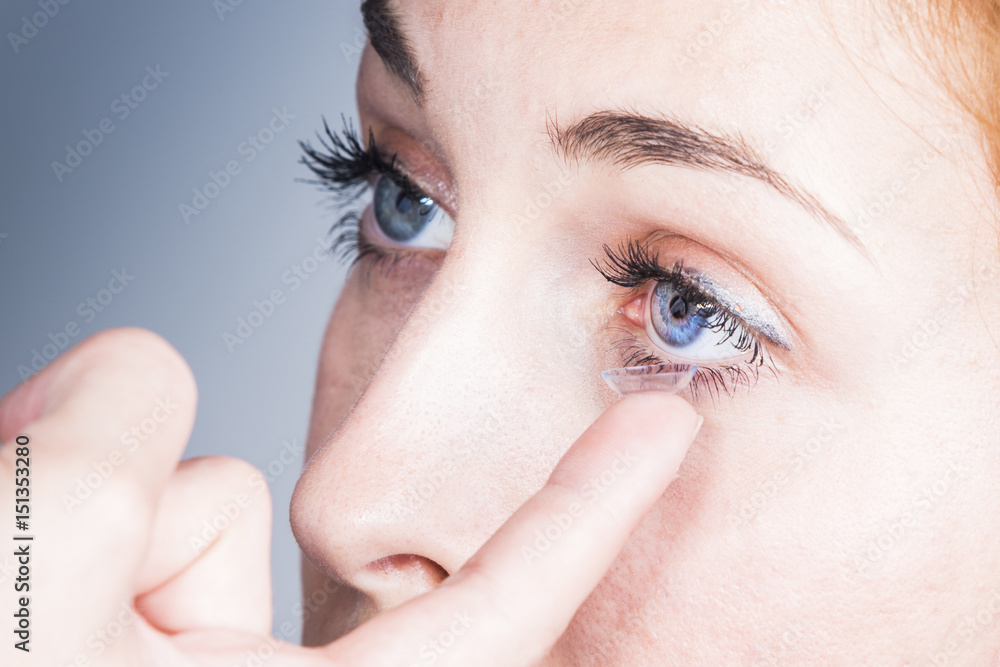 Fototapeta premium Young woman puts a contact lens