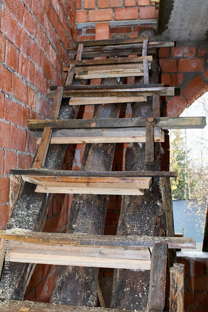 Wet wooden staircase in a brick building under construction. Wet wooden staircase in a brick building under construction.