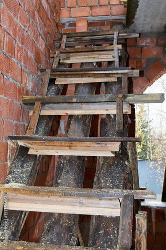 Wet wooden staircase in a brick building under construction. © kurbanov_vener