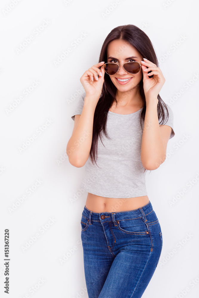 Attractive playful girl with nice smile in stylish spectacles is fixing them on the pure white background. She is flirty and tempting Attractive playful girl with nice smile in stylish spectacles is fixing them on the pure white background. She is flirty and tempting