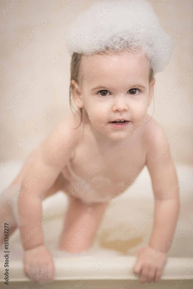 Adorable child blond girl with soap suds on hair taking bath Adorable child blond girl with soap suds on hair taking bath