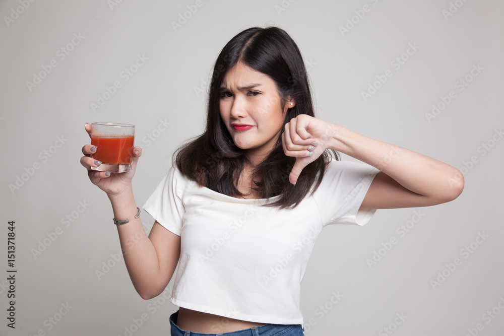 Asian woman thumbs down hate tomato juice. Asian woman thumbs down hate tomato juice.