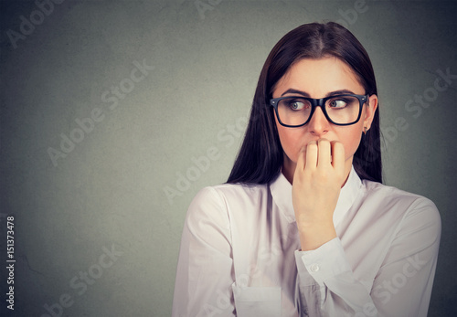 Unsure anxious woman biting her fingernails craving for something photo
