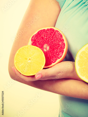 Woman holding fruits kiwi. orange, lemon and grapefruit