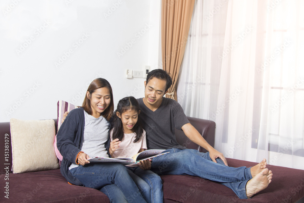 Parents sitting with daughter reading story indoors Parents sitting with daughter reading story indoors