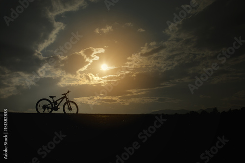 Silhouette sport bicycle with beautiful sun sky romance view background