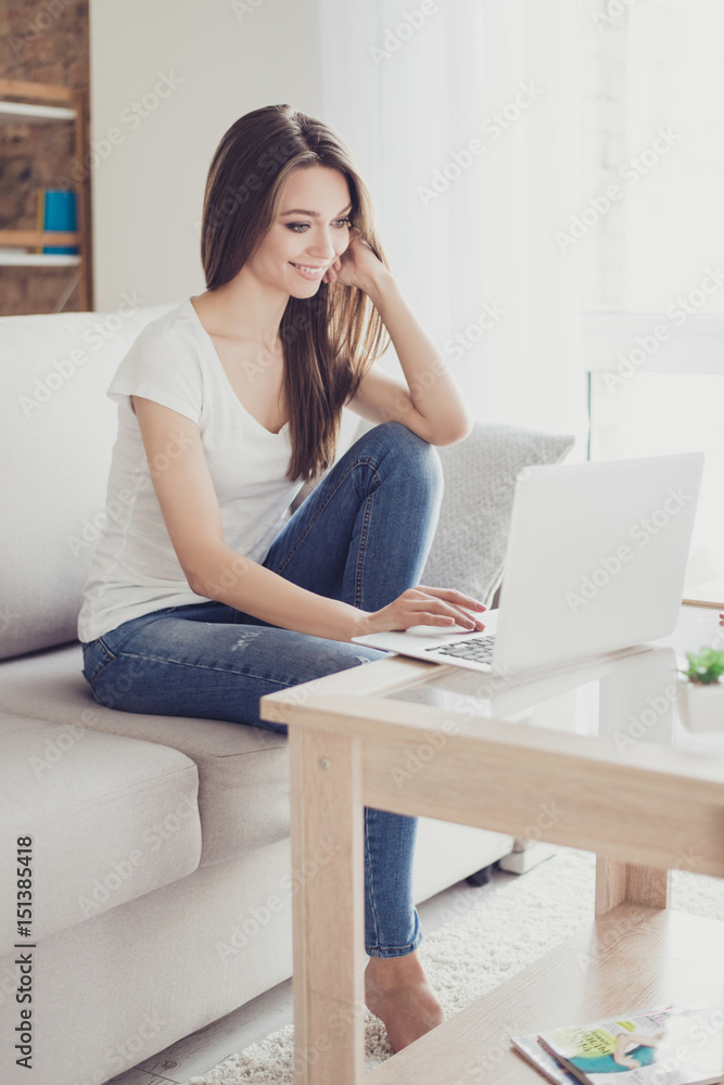 Young pretty woman working with laptop sitting on the sofa Young pretty woman working with laptop sitting on the sofa