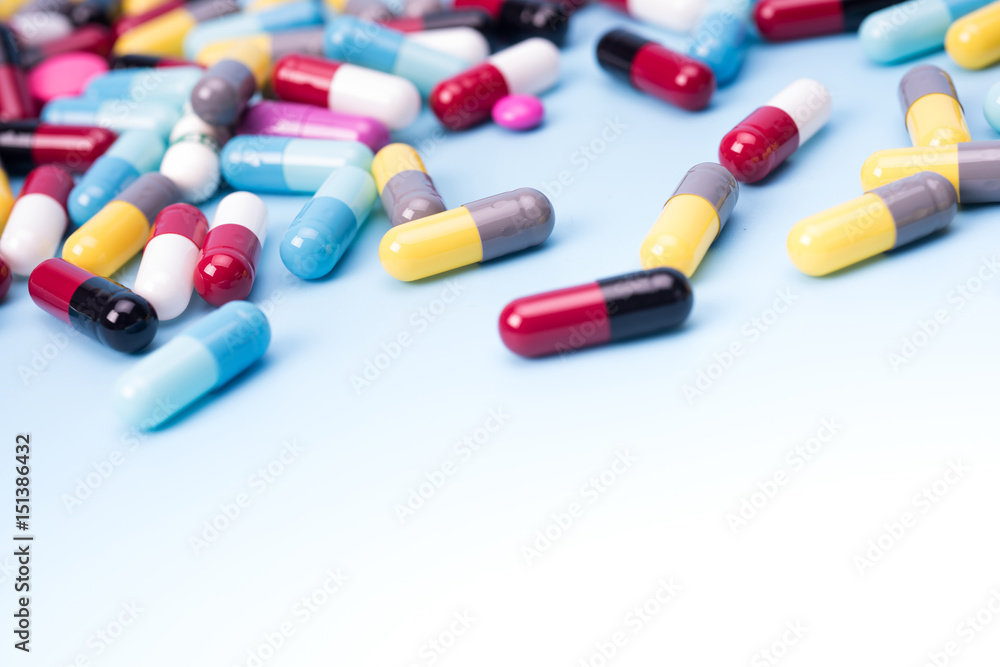 many scattered Colorful pills on blue background. many scattered Colorful pills on blue background.