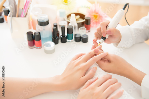 salon manicurist using electric nail drill