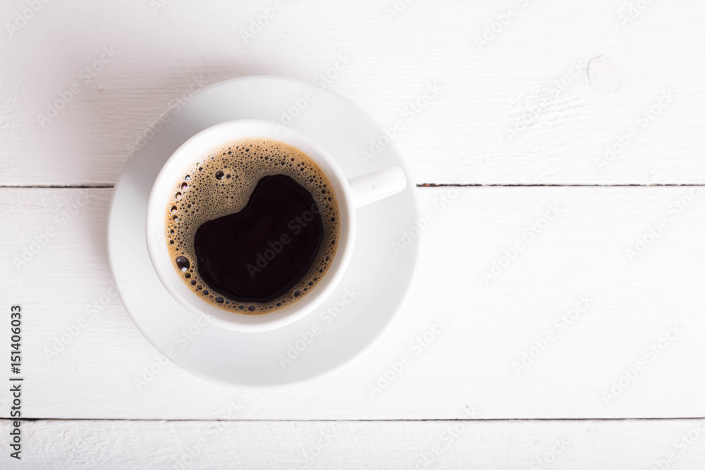Black coffee in a white cup on a white background. Selective focus. Place for text or inscription. Copy plase. Top view. Black coffee in a white cup on a white background. Selective focus. Place for text or inscription. Copy plase. Top view.