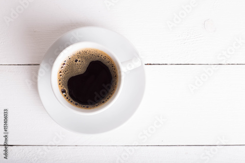 Black coffee in a white cup on a white background. Selective focus. Place for text or inscription. Copy plase. Top view.