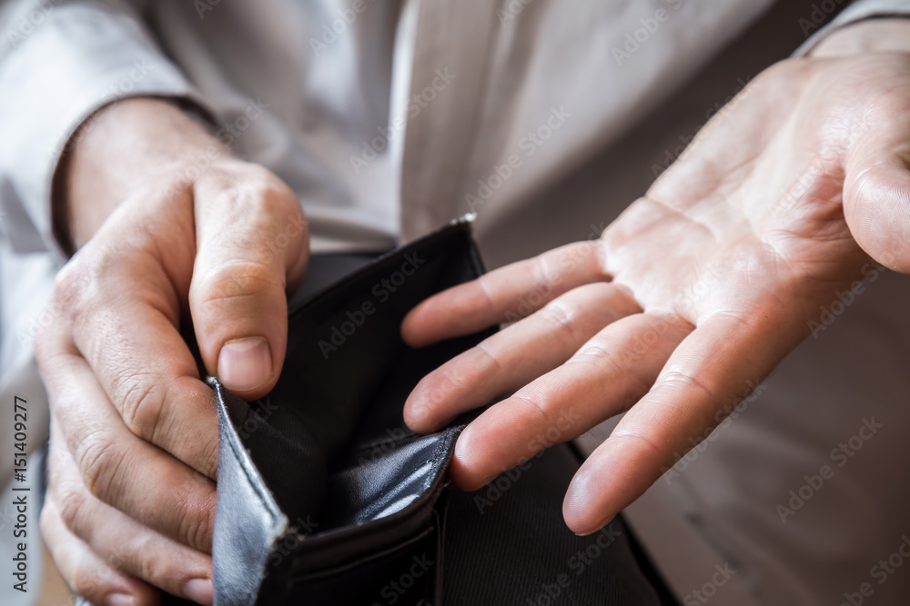 Man's hand holding an empty black money wallet. 