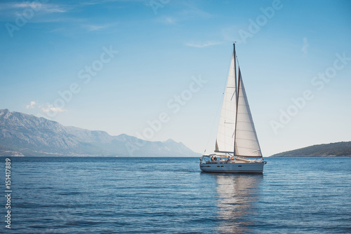 Sailing yacht in the sea against the backdrop of mountains © Maxim Sokolov