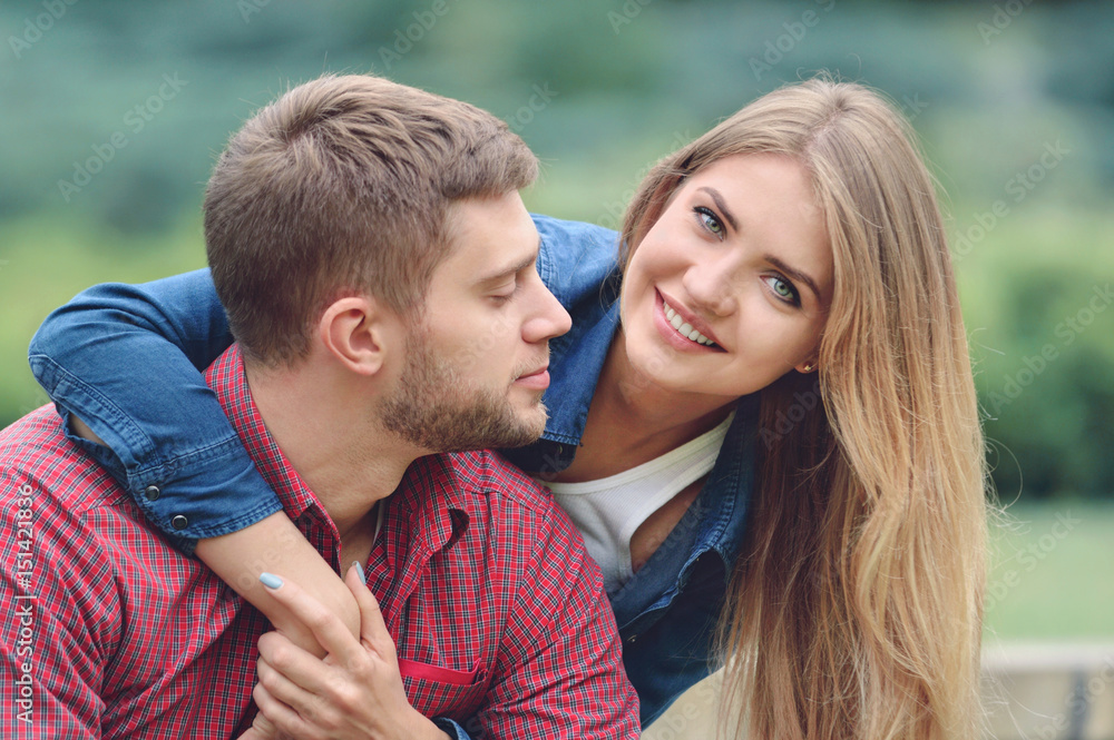 Romantic couple sitting on bench, hugging and smiling Romantic couple sitting on bench, hugging and smiling
