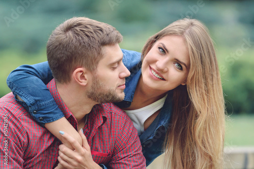 Romantic couple sitting on bench, hugging and smiling